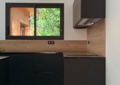 Cuisine noire et bois sous fenêtre, réalisation sur mesure