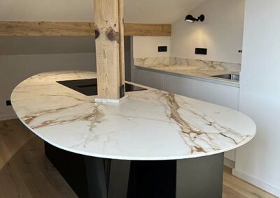 Îlot arrondi en céramique veinée et poutre en bois, cuisine à Biarritz