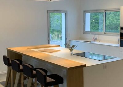 Cuisine avec îlot en bois et tabourets noirs