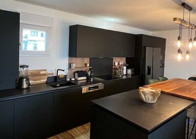 Cuisine noire avec îlot et plan de travail en bois