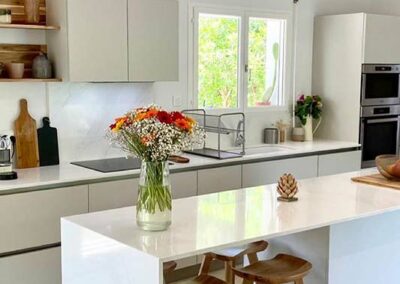 Cuisine blanche avec îlot et plan de travail clair
